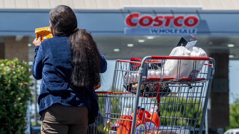 Woman pulling groceries from Costco cart